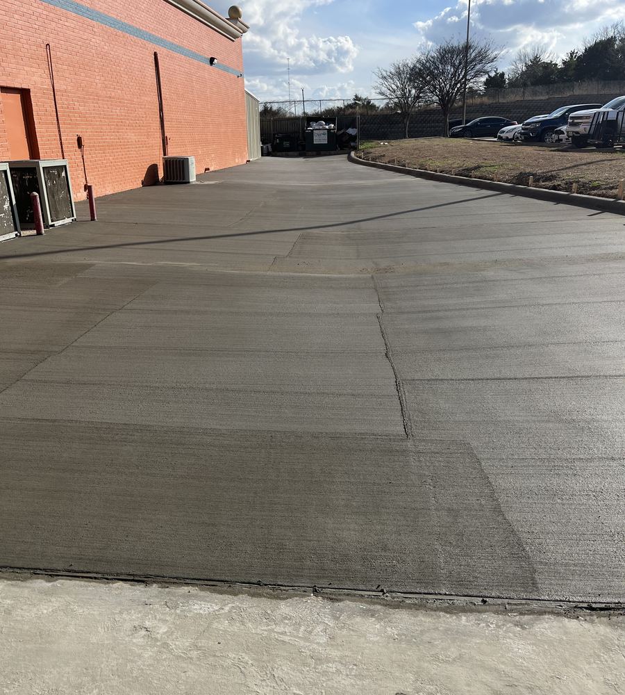 Finished commercial concrete drive beside a brick building