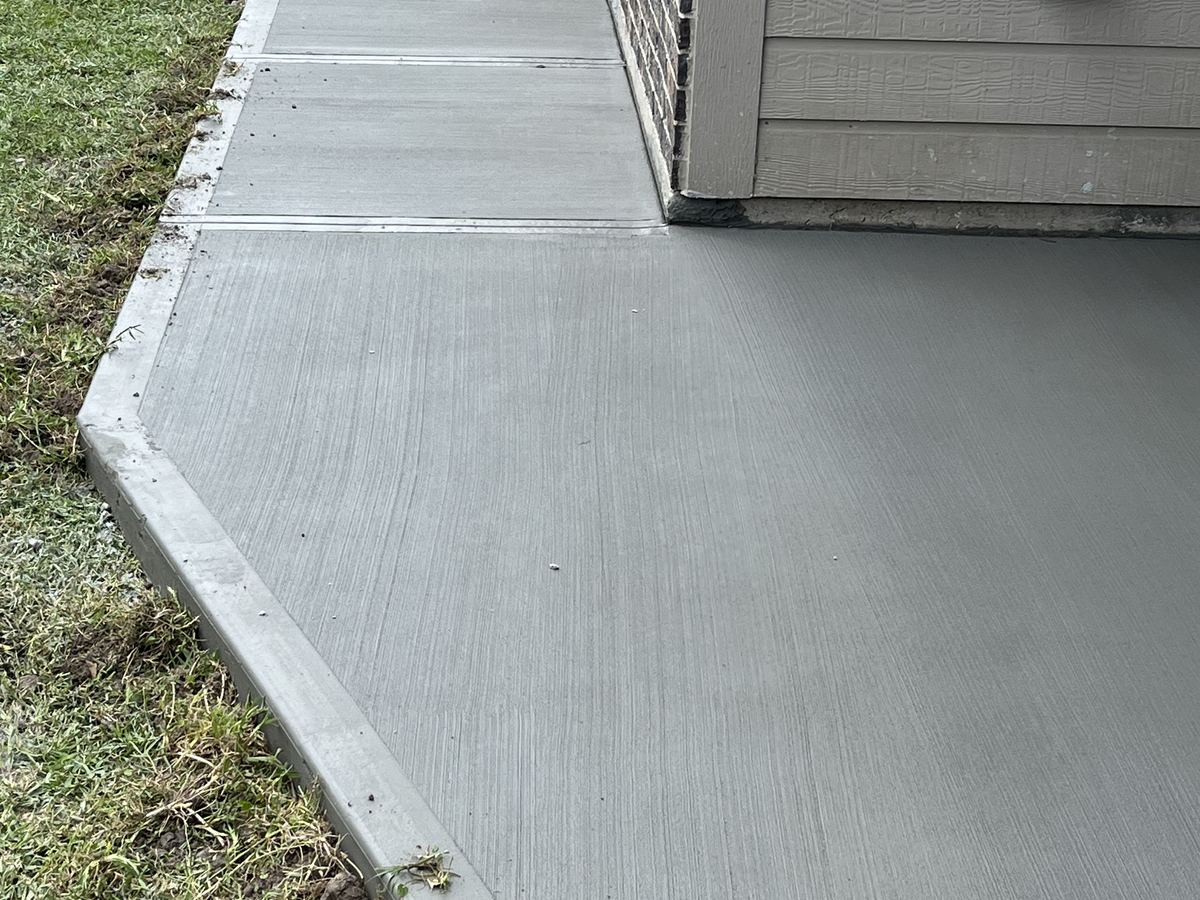 Finished concrete walkway running alongside a home