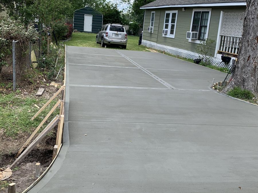 Finished concrete driveway curving up to a home